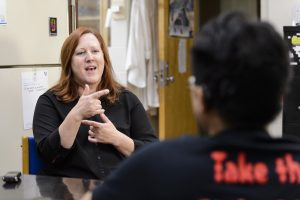 A sign-language interpreter with the McBurney Disability Resource Center gestures as she translates a conversation for a doctoral student in the University of Wisconsin-Madison's Cellular and Molecular Pathology Graduate Program.